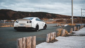 white nissan gtr parked on a cloudy day