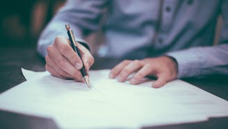 business professional signing paperwork at a desk