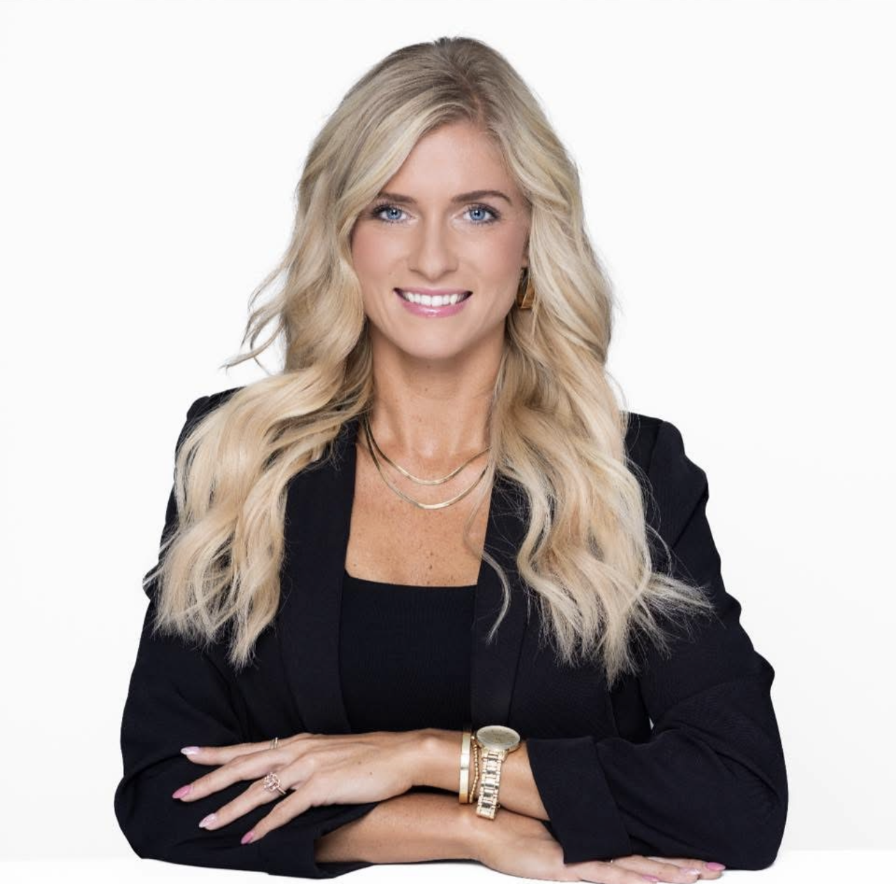 woman in black blazer with long blonde hair and bright smile