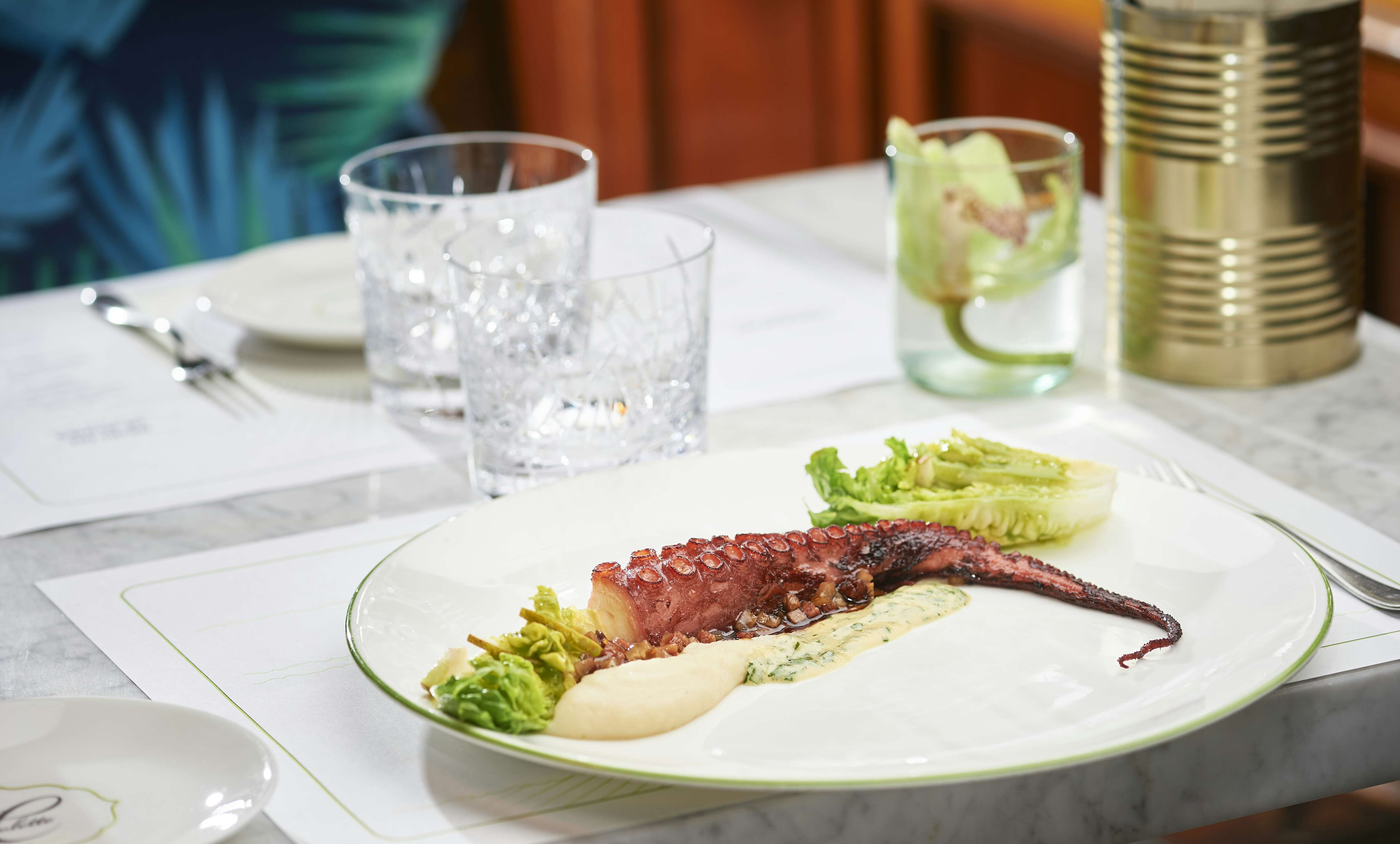 Teller mit Pulpo auf gedecktem Marmortisch