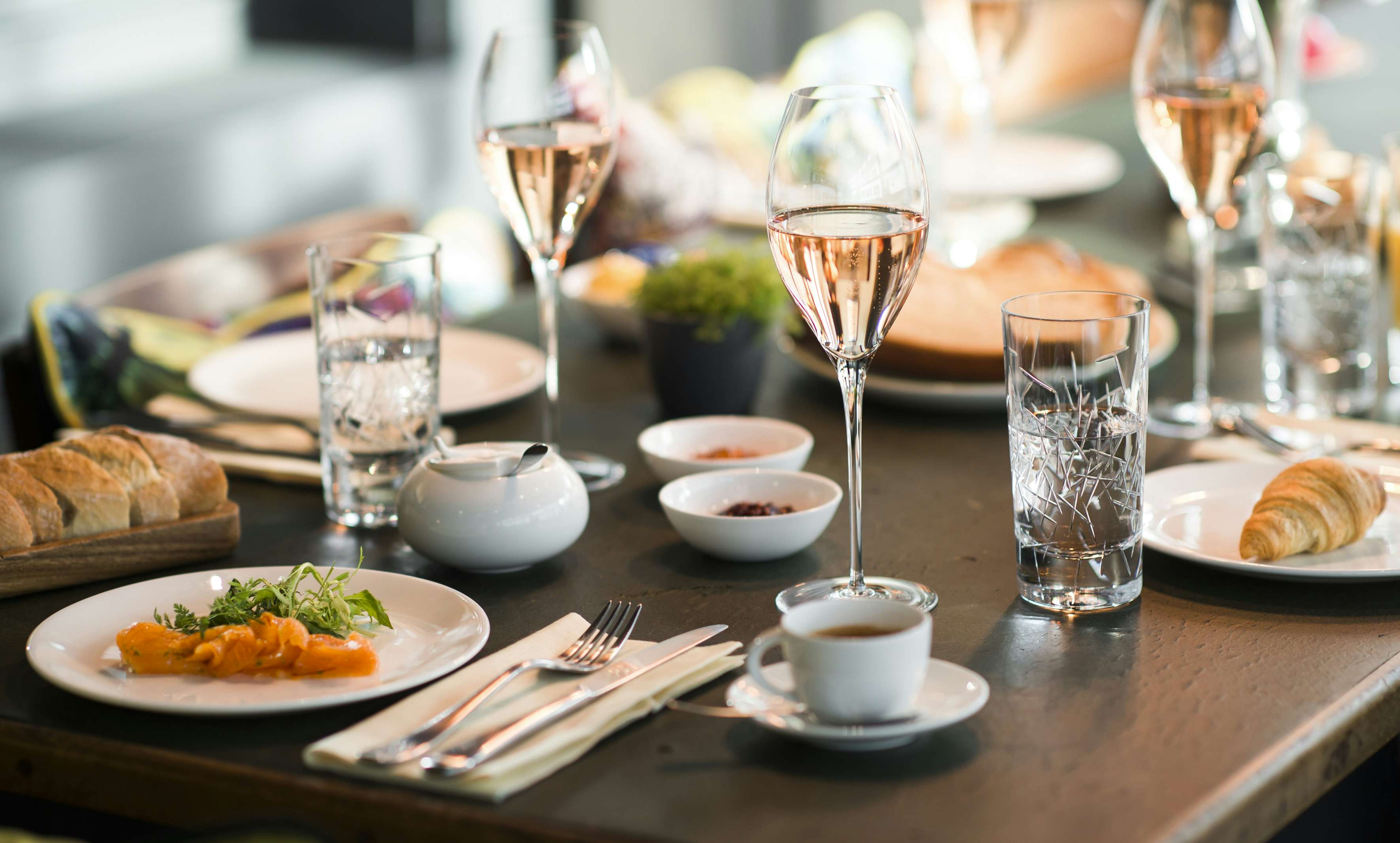 Brasserie Colette Berlin - gedeckter Tisch mit französischen Gerichten, Wein und Kaffee.