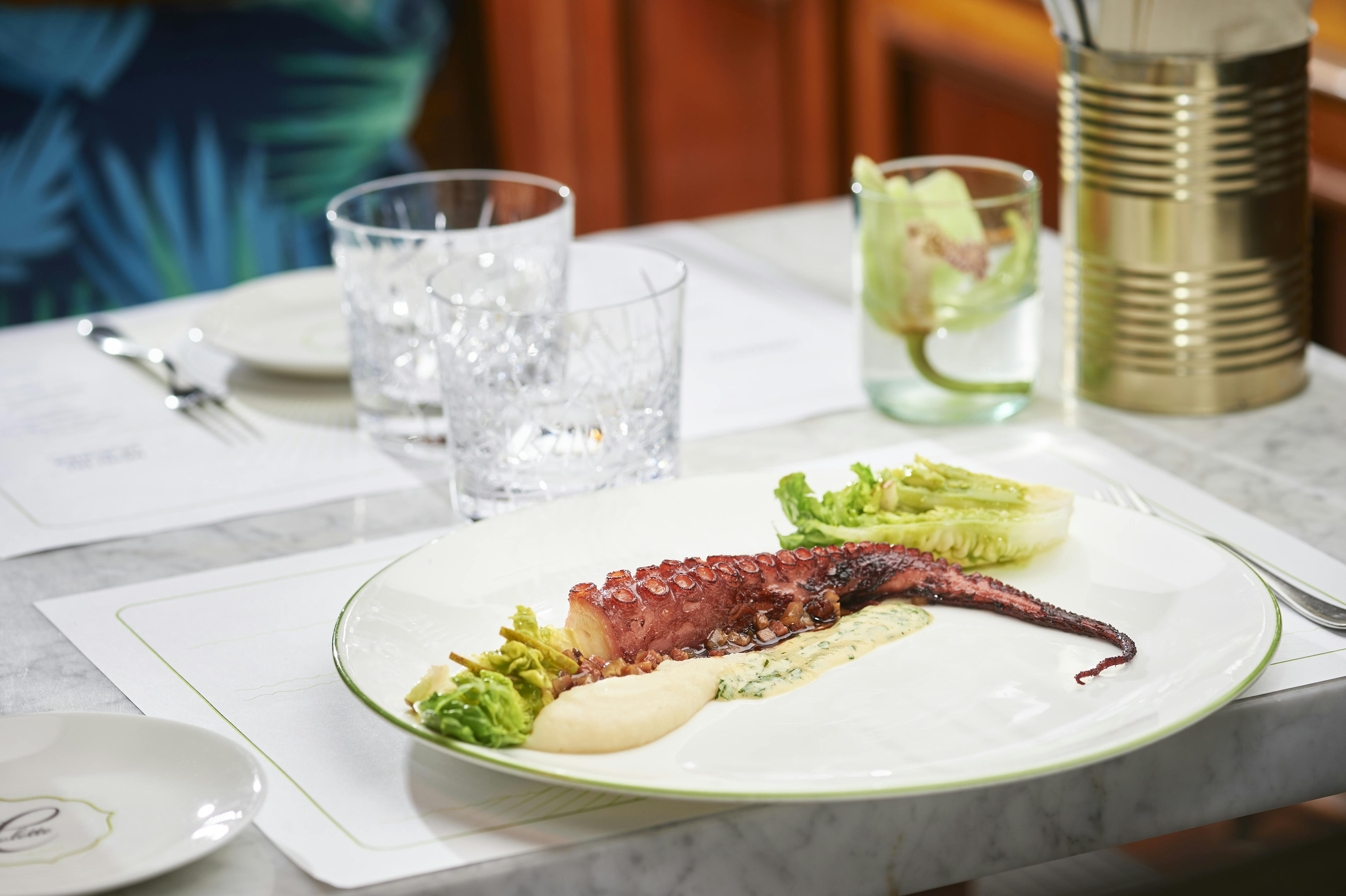Plate with pulpo on set marble table