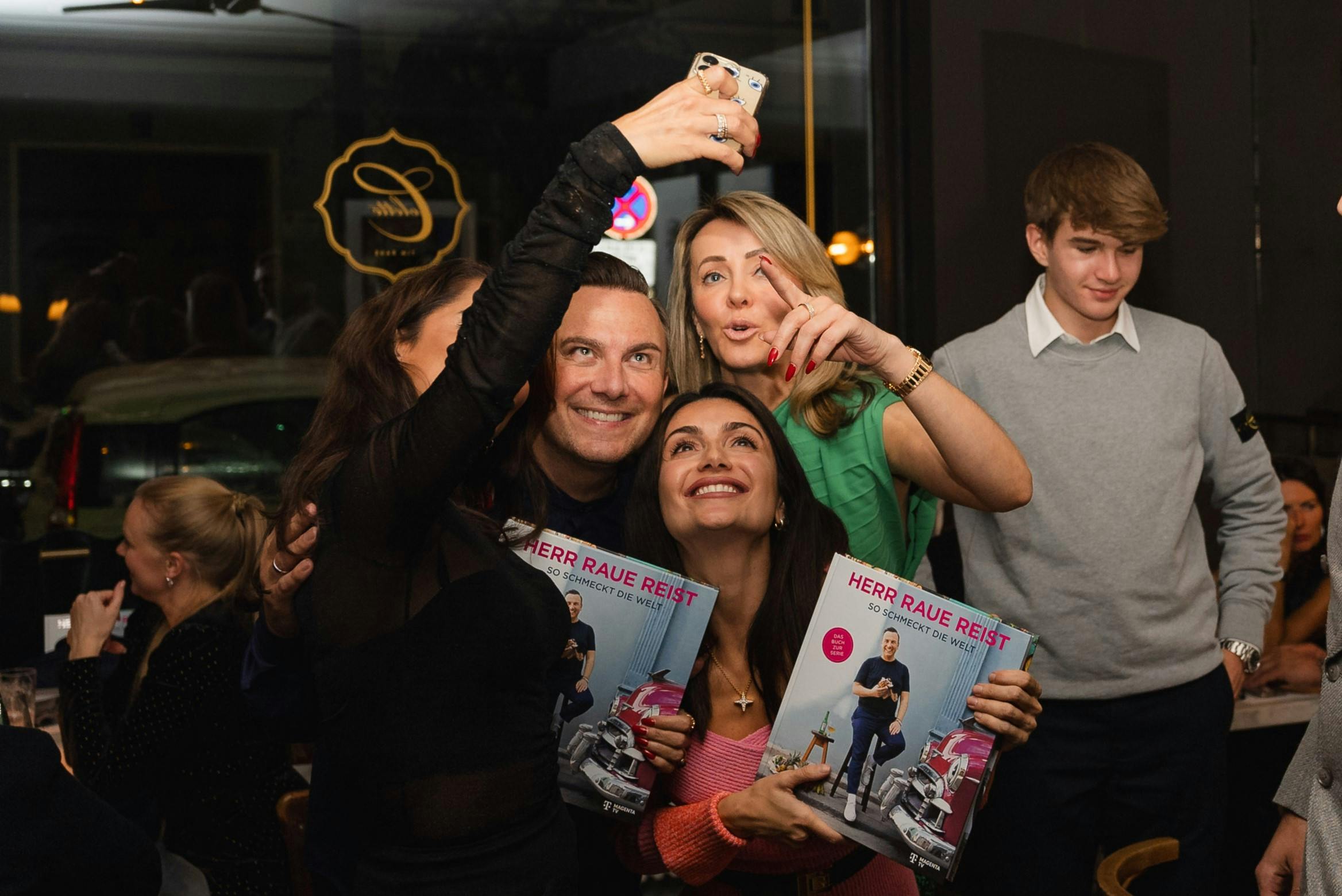 Tim Raue posiert mit Fans für ein Selfie
