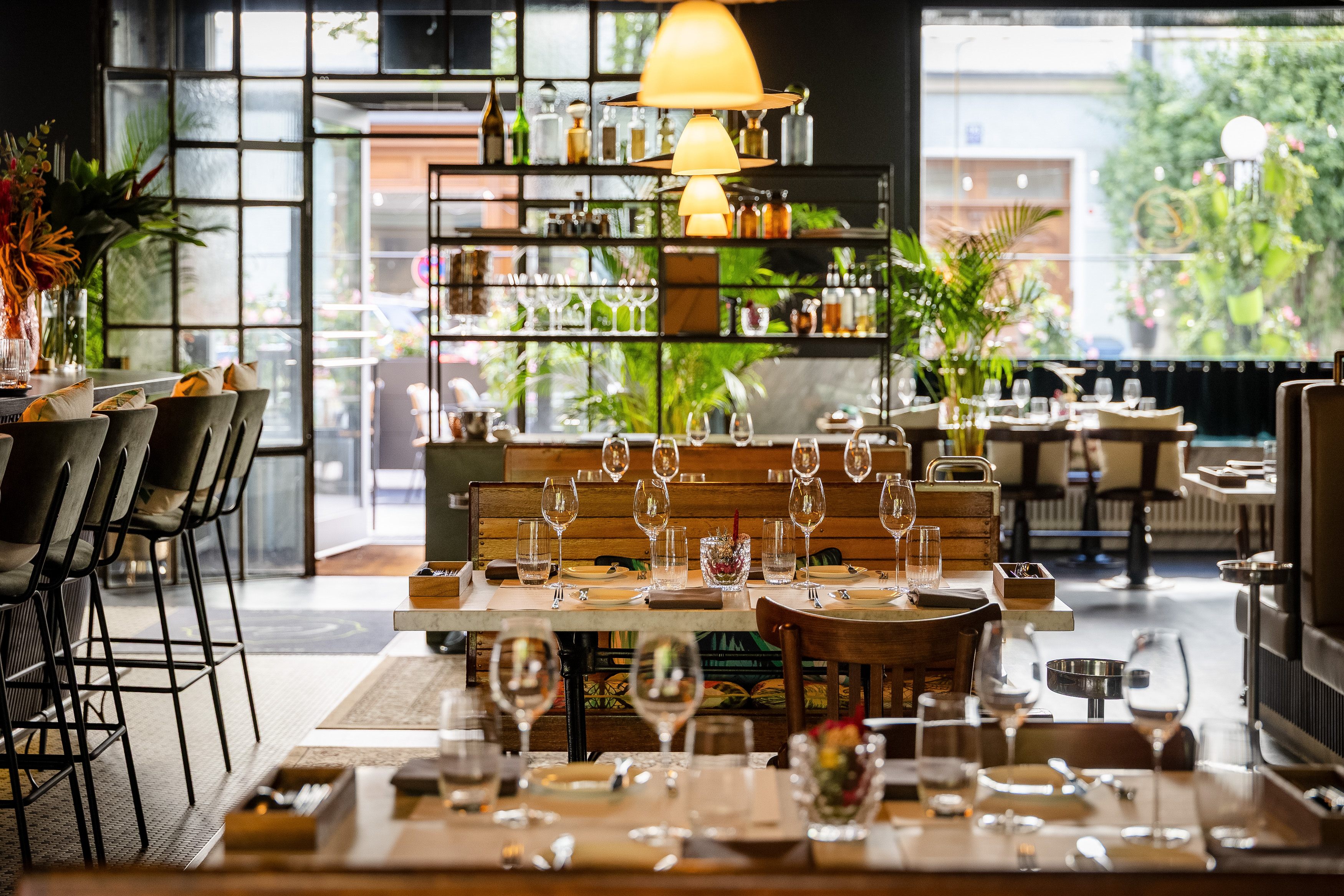 Brasserie Colette in München mit gedeckten Tischen, im Vordergrund Weingläser