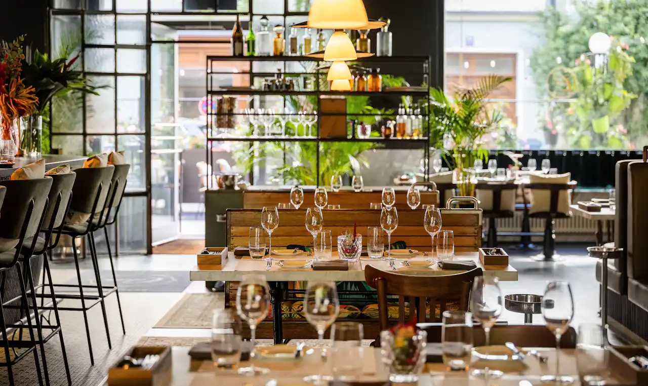 Brasserie Colette in München mit gedeckten Tischen, im Vordergrund Weingläser
