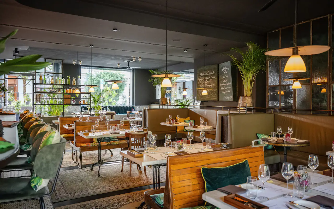 Innenansicht der Brasserie Colette in München mit gedeckten Tischen