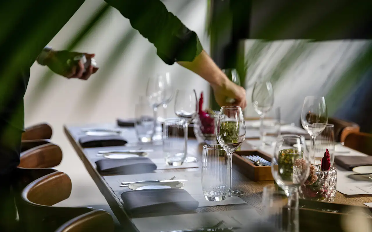 Ein Kellner deckt Weingläser auf in der Brasserie Colette
