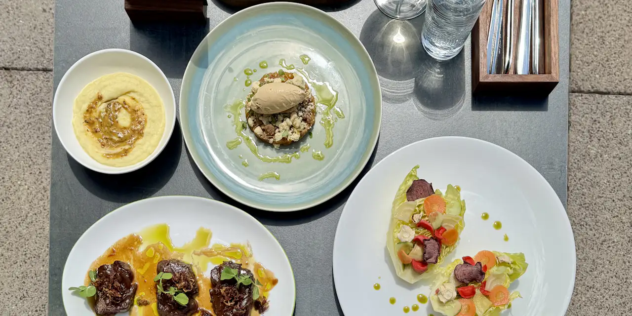 Restauranttisch von oben fotografiert mit 3 Gänge Menü und Dessertteller