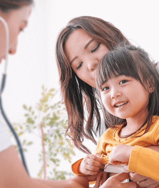 Doctor with stethoscope checking child’s heart beat