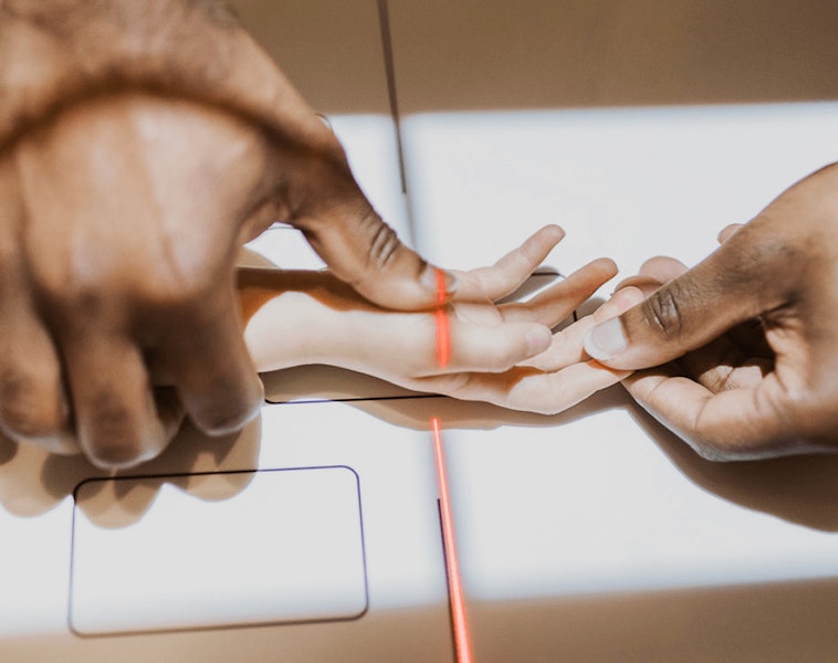Adult hands holding a child's hand during imaging