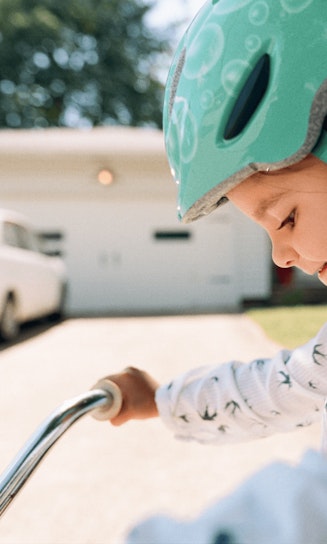 Child wearing helmet while riding a bike
