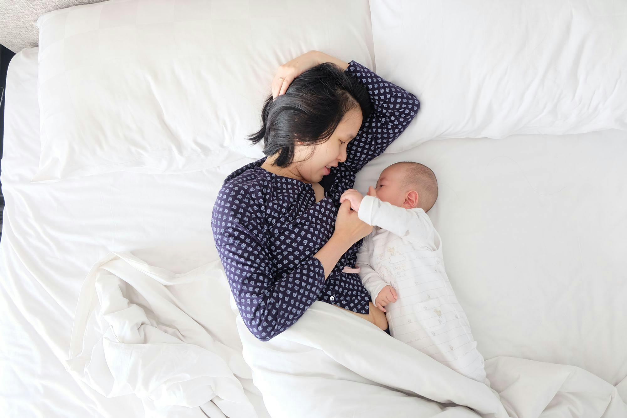 A woman laying next to her baby. 