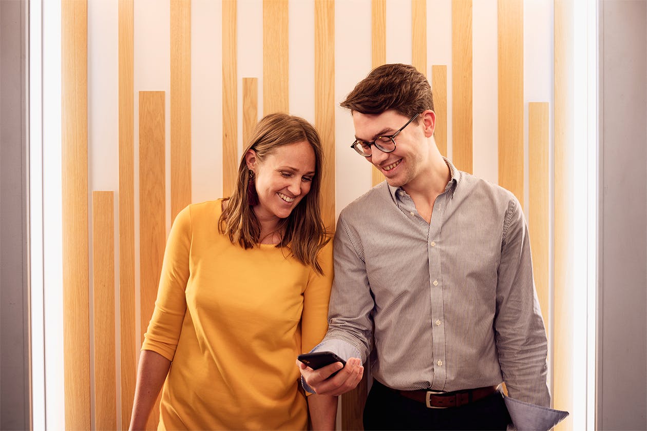 Two people looking at a mobile phone