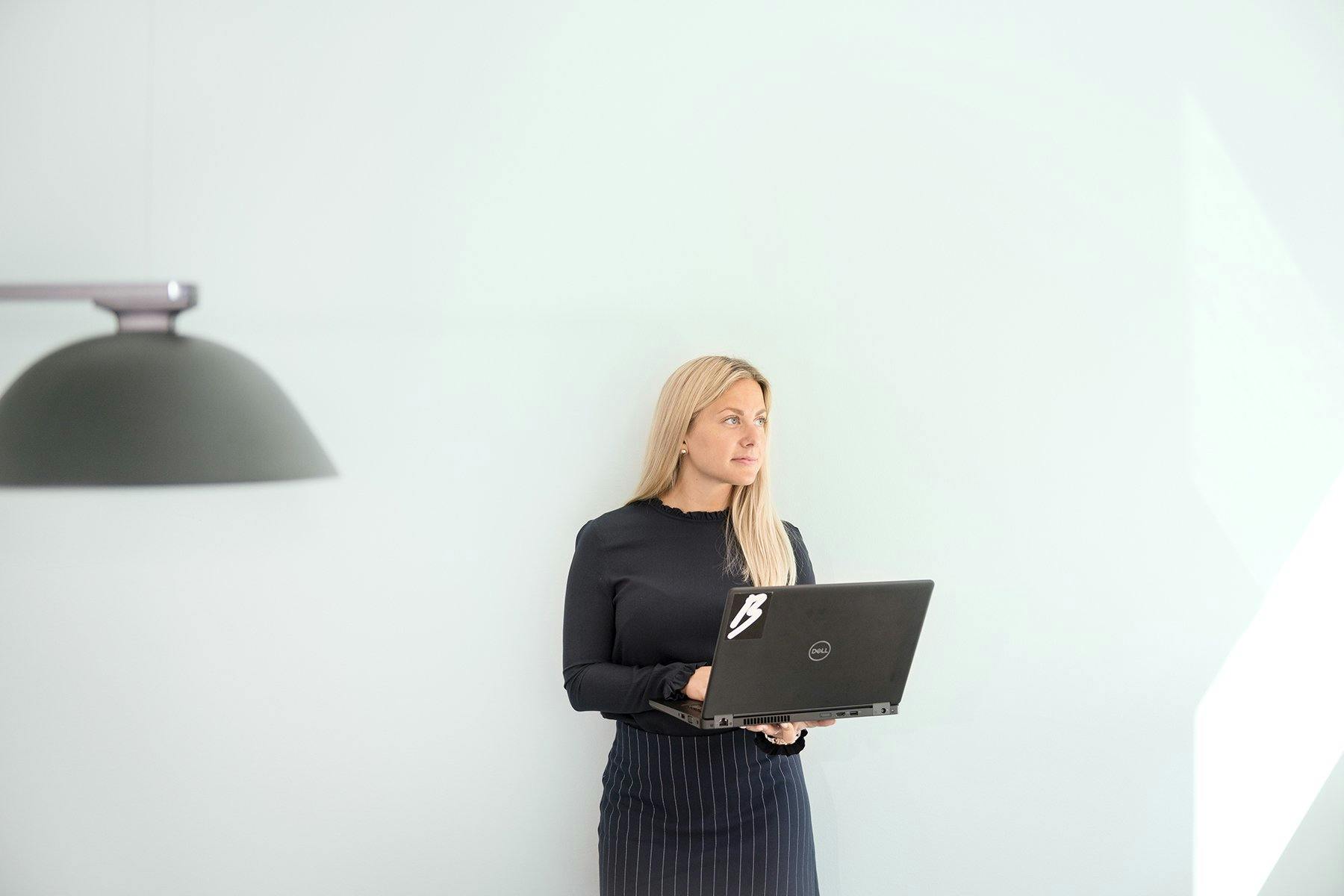 Kvinna på Bravuras kontor med laptop i handen