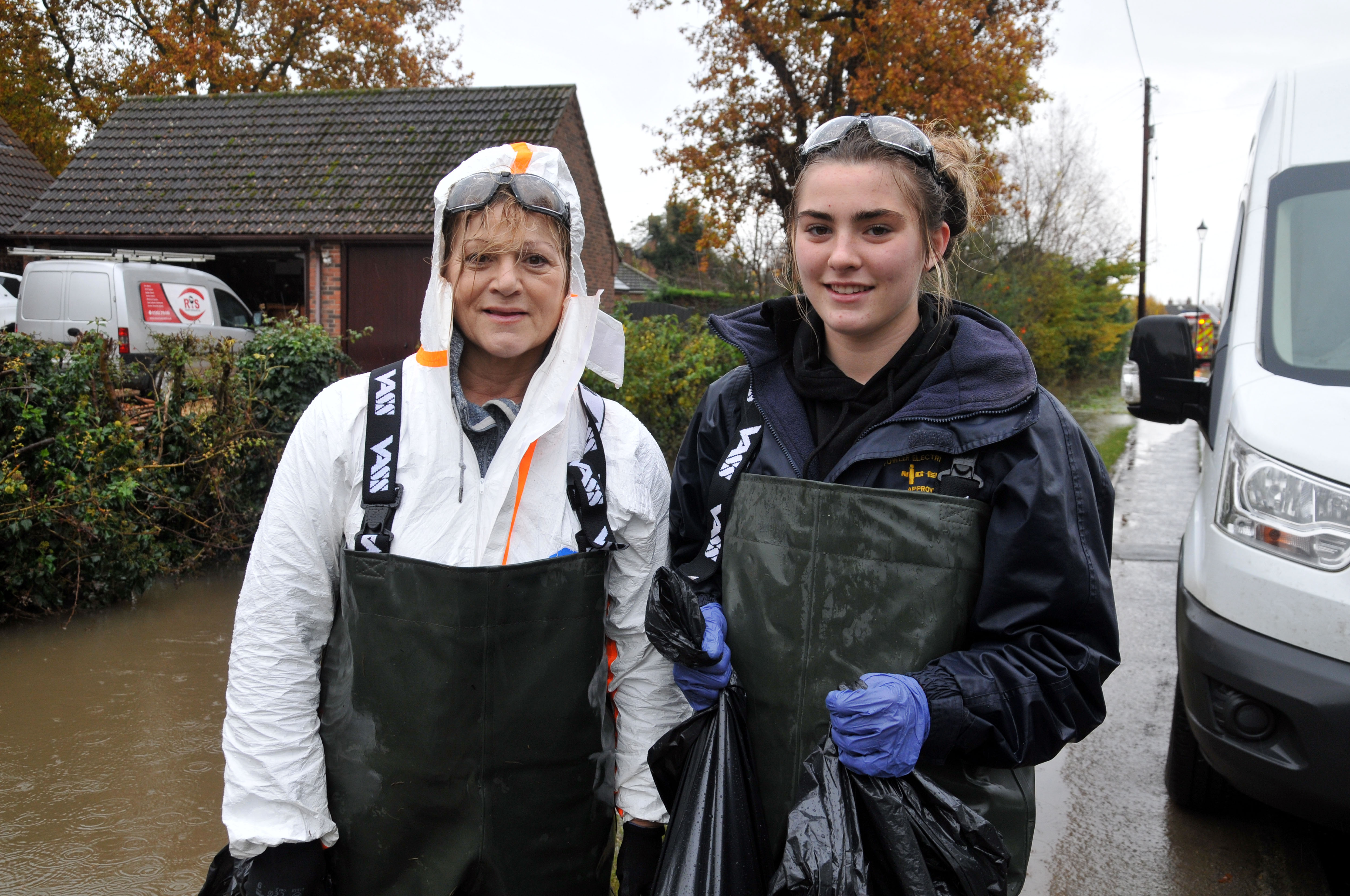 Picture of Amy (right) and her mother Ann (left) helping clean up the village of Fishlake following widespread floods. Ann and Amy are wearing protective goggles and flood suits.