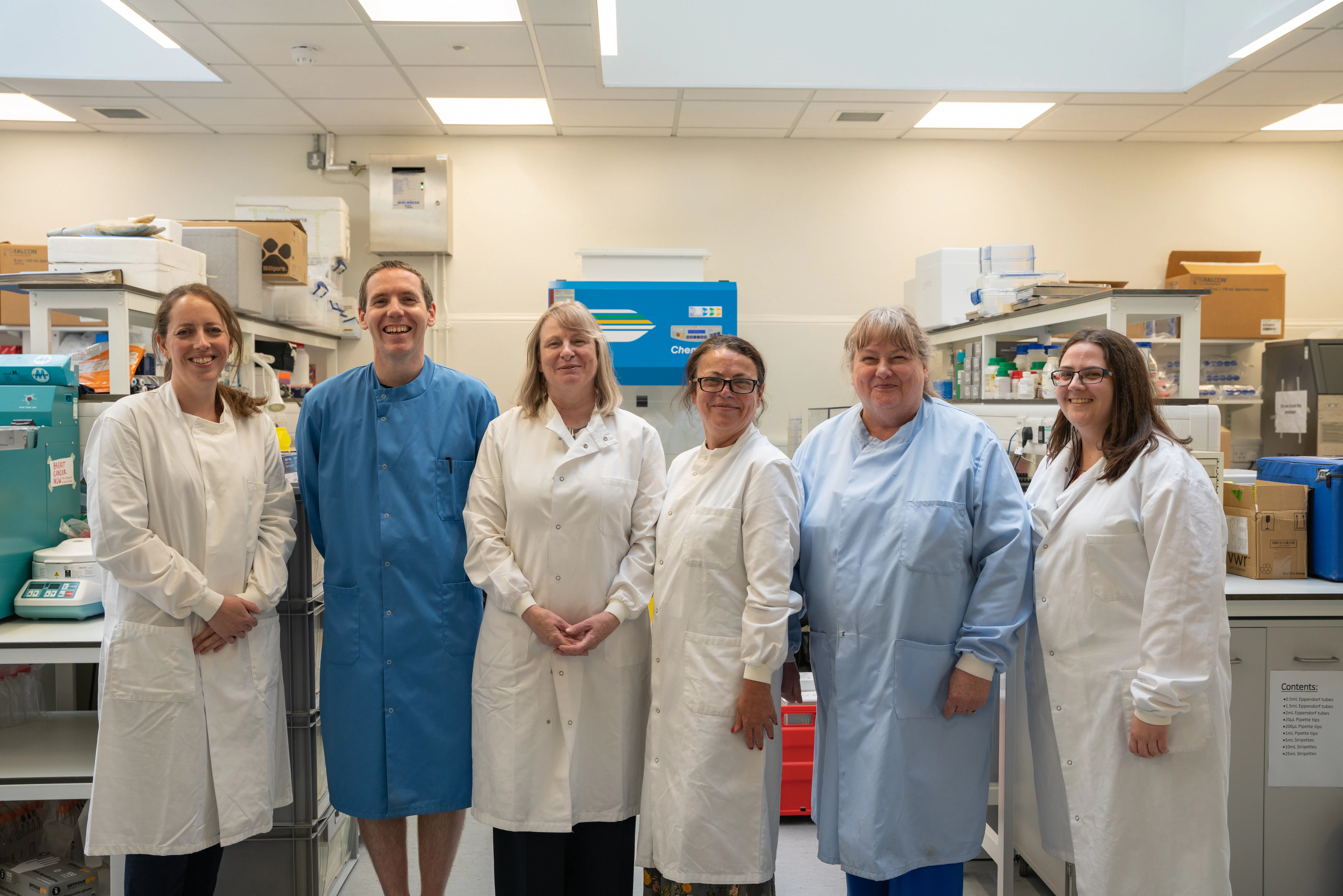 Smiling researchers in lab coats.