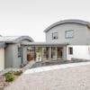 Luxury property clad in light coloured Cape Cod timber cladding