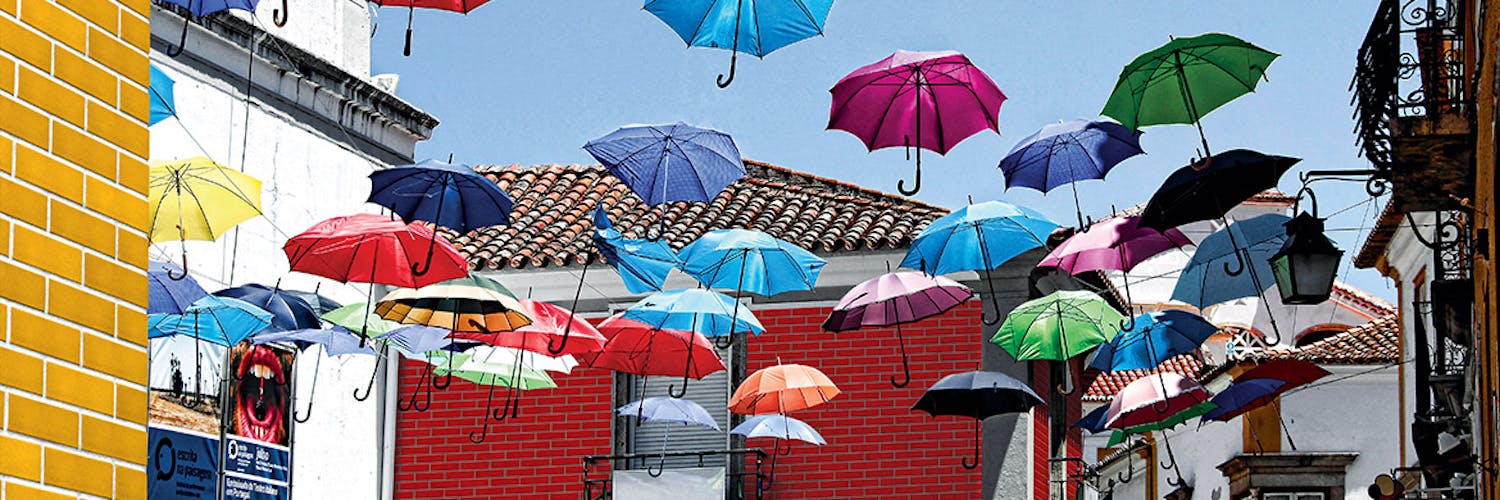 Colourful suspended umbrellas contest with old buildings clad in castle collection brick slips