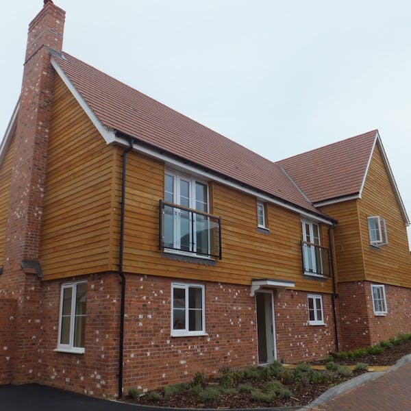 A large detached dwelling clad in timber and brick slips