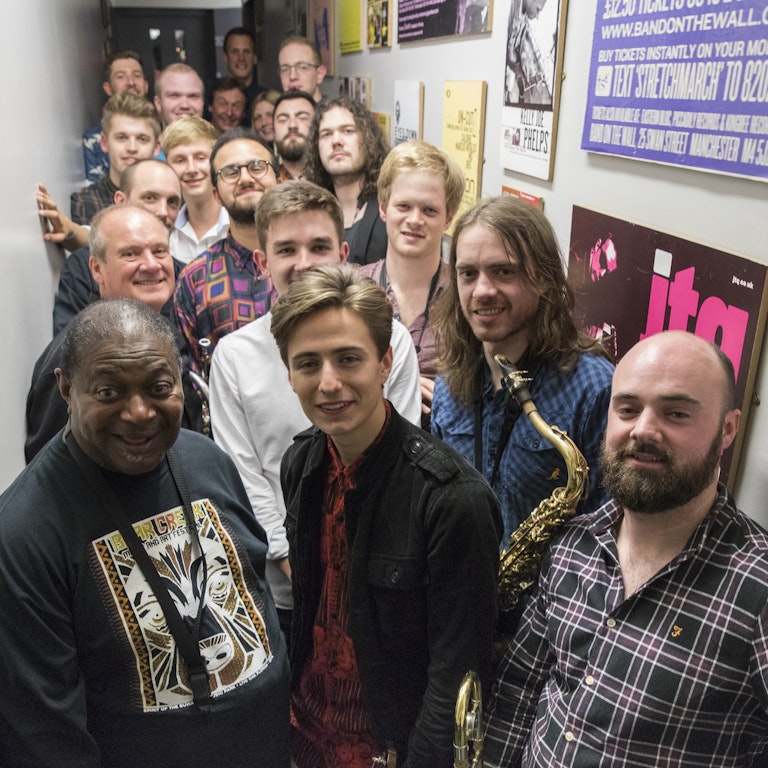 All musicians from Pee Wee Ellis' FUNK Foundation, plus Pee Wee Ellis and Gary Winters, stood together backstage for a portrait.