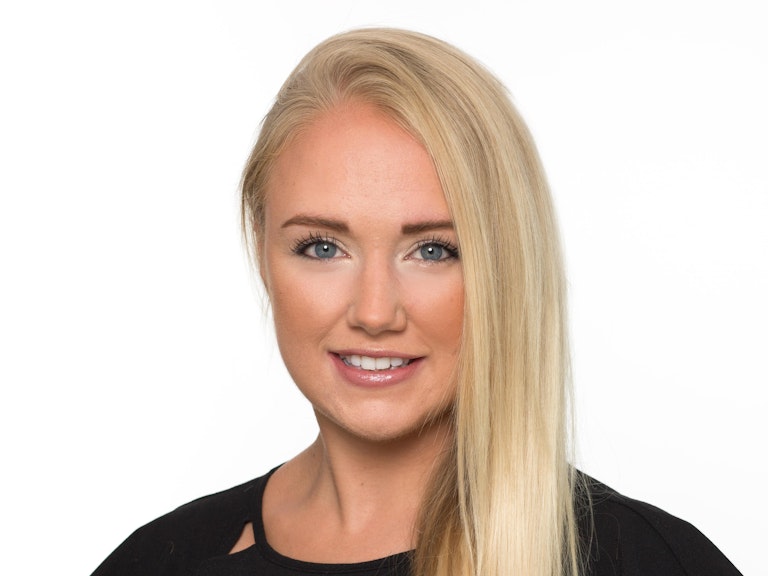 A professional headshot of Lyndsey Shaw. She is smiling into the camera. Her long blonde hair falls down past one shoulder.