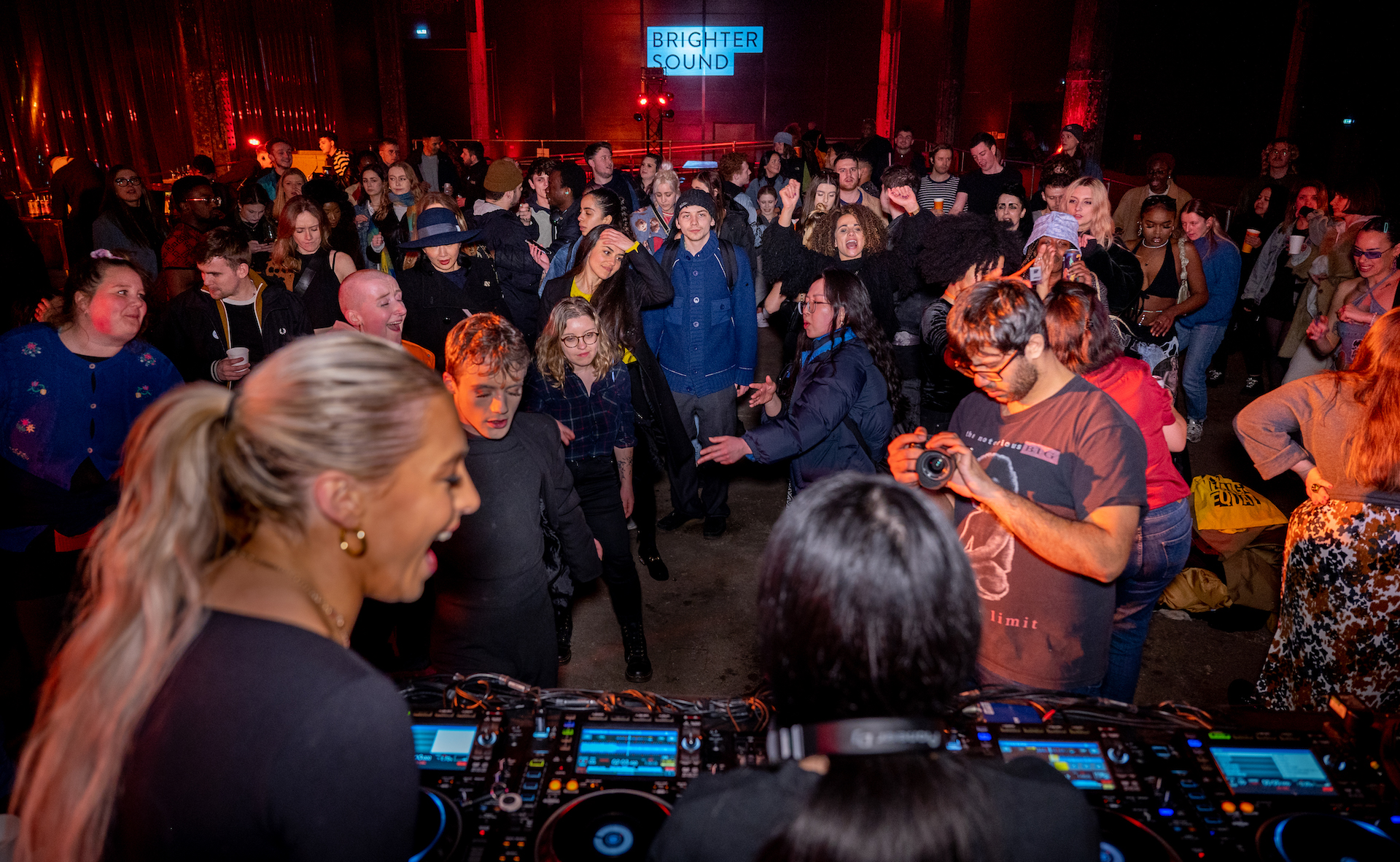 A crowd of people dancing and watching DJ collective Girls Don't Sync.