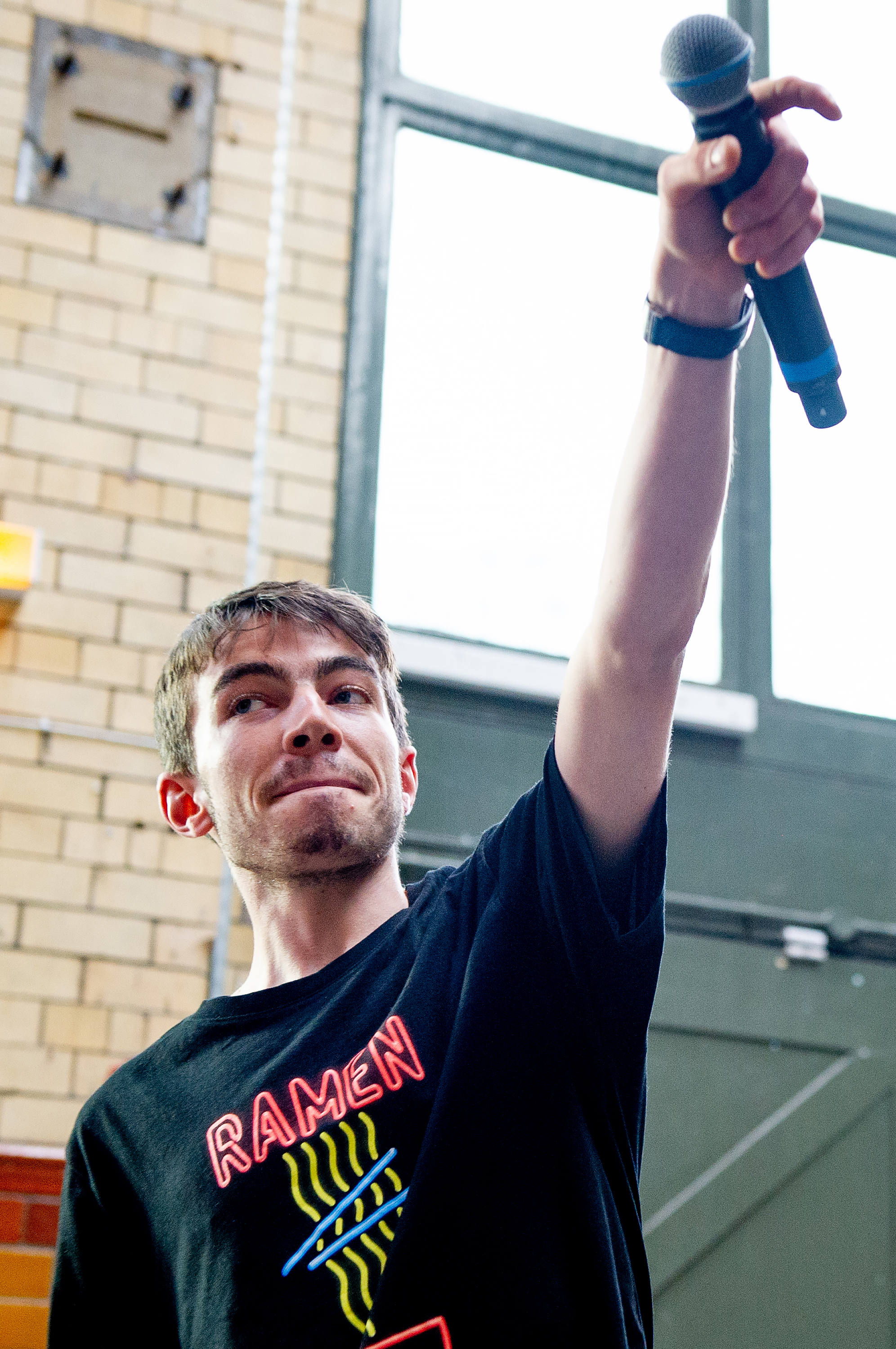 Kin Louie holding his microphone in the air.