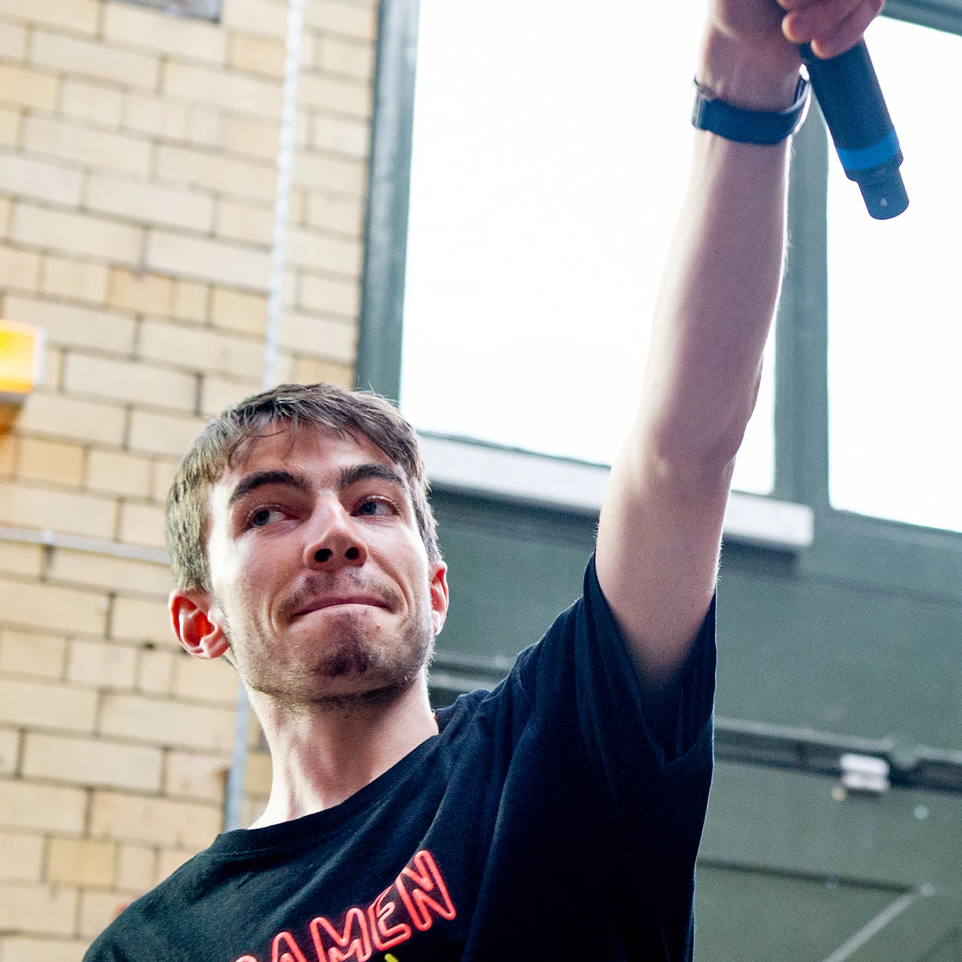 Kin Louie holding his microphone in the air.
