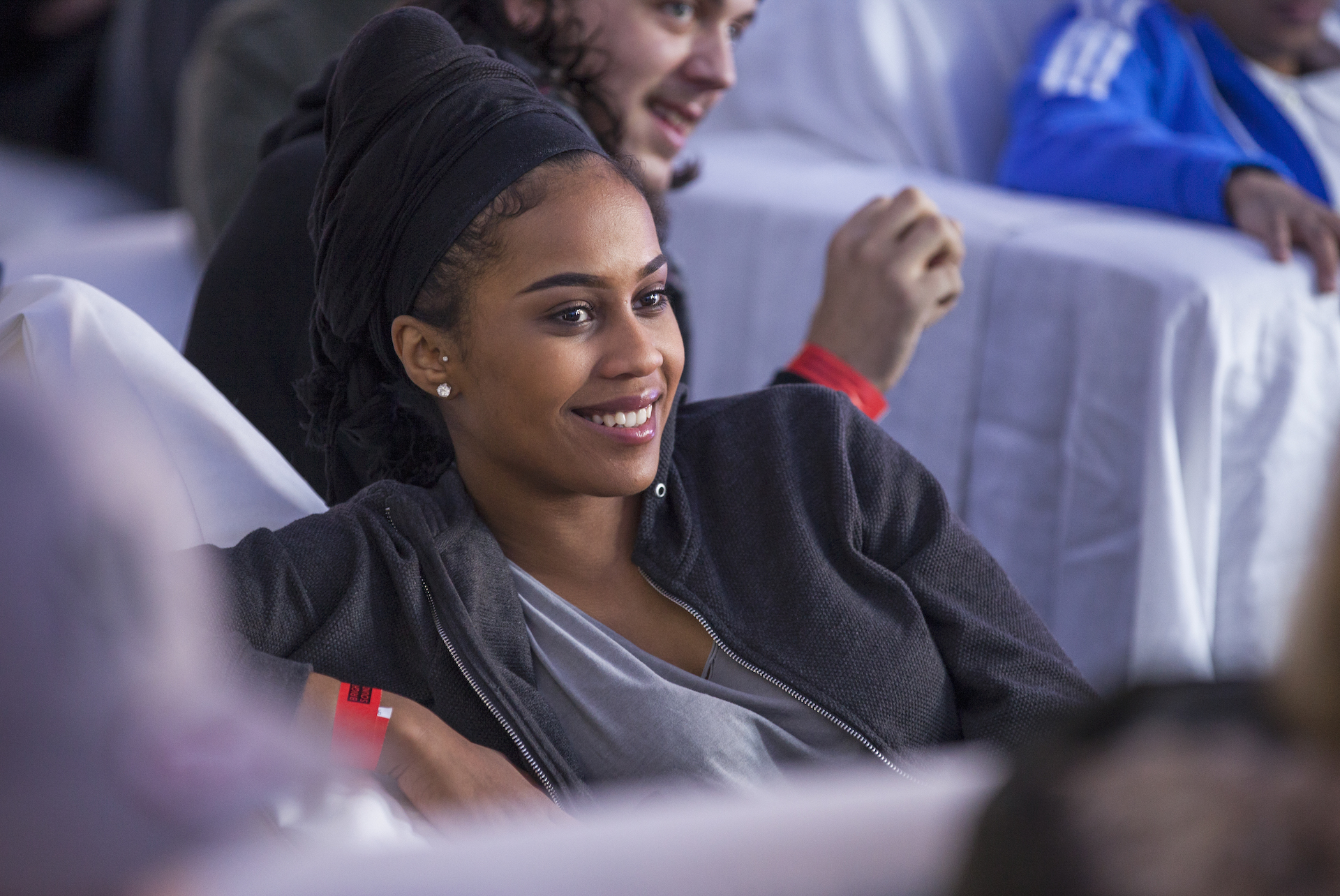 Close up of a smiling participant who is sitting on a white chair. 