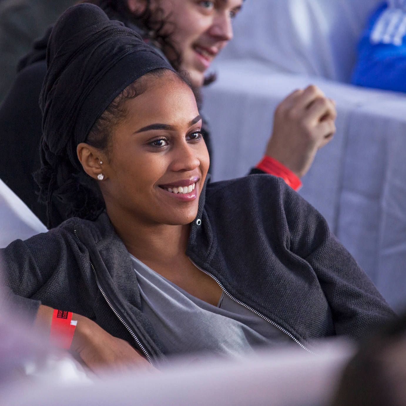 Close up of a smiling participant who is sitting on a white chair.