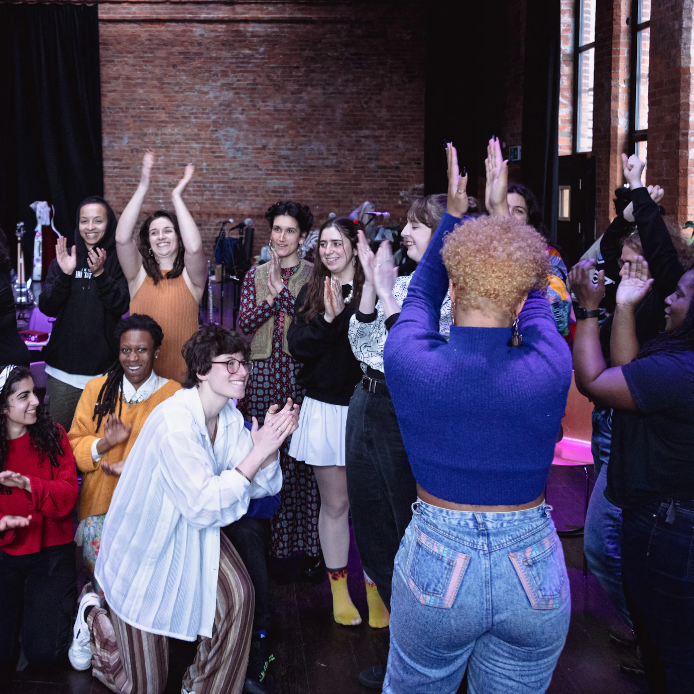 Nubya Garcia and the residency participants smiling and applauding one another in a group.
