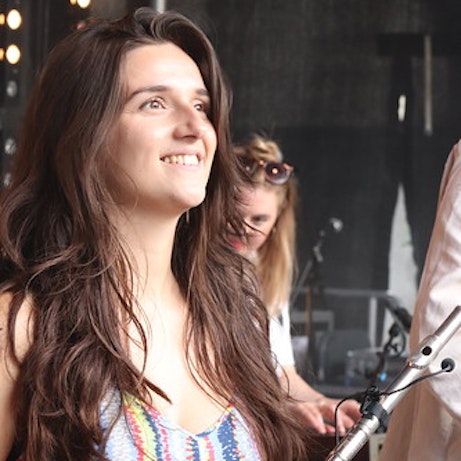 Caroline Webb holding a flute smiling off into the distance.