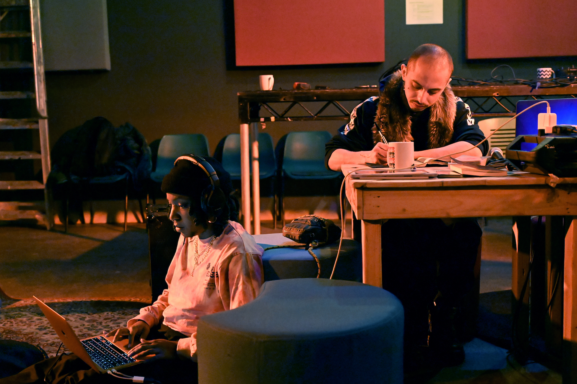 Residency artists writing and working on laptops.