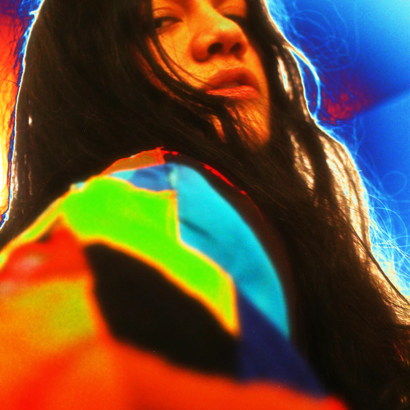 A close up of Yeguachita looking into the camera. The headshot has a heatkap style tint to it, adding reds, greens and blues to the photo.