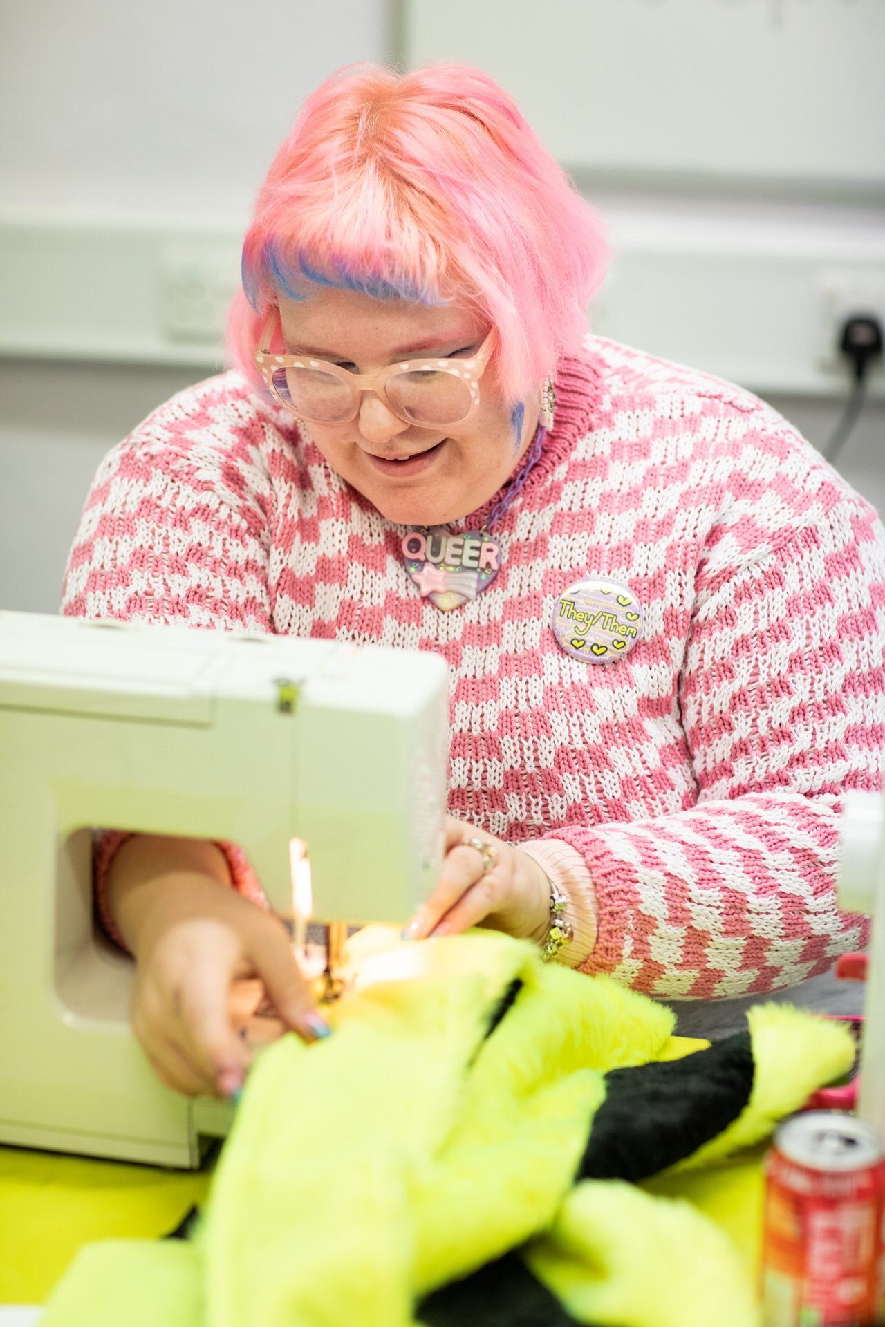 Eleanor Louise West using a sewing machine on bright green material as part of the Self, Sense, Space residency.