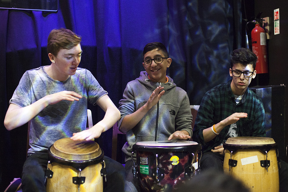 Drummers sat side by side and smiling.