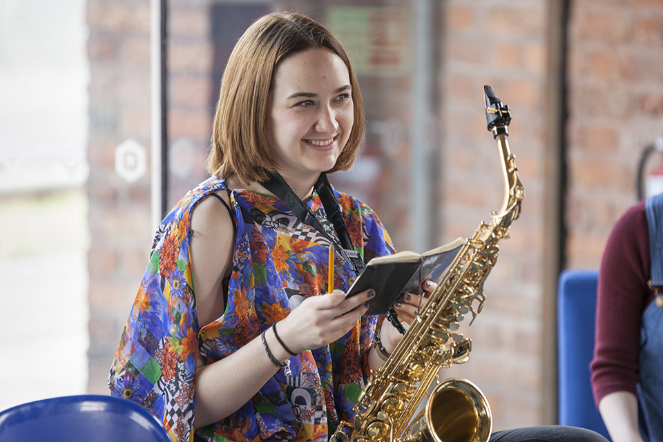 A saxophonist with a notebook.