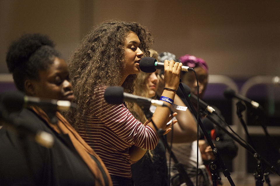 Musicians singing into microphones.