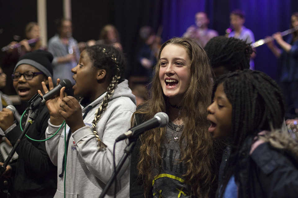 Musicians singing into microphones.