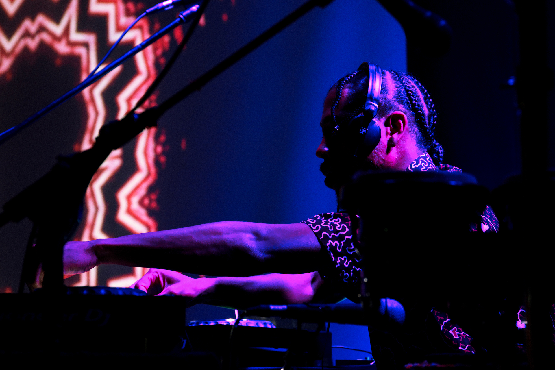 Obeka performing with visuals behind.