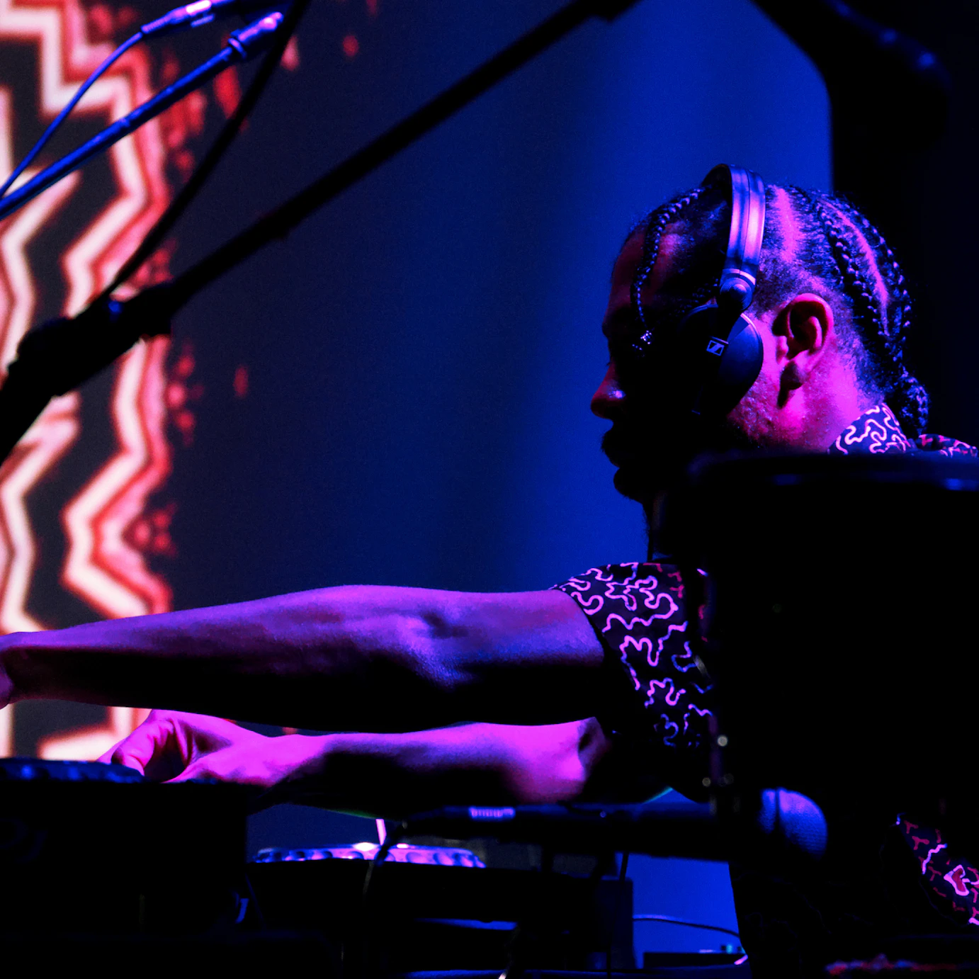 Obeka performing with visuals behind.