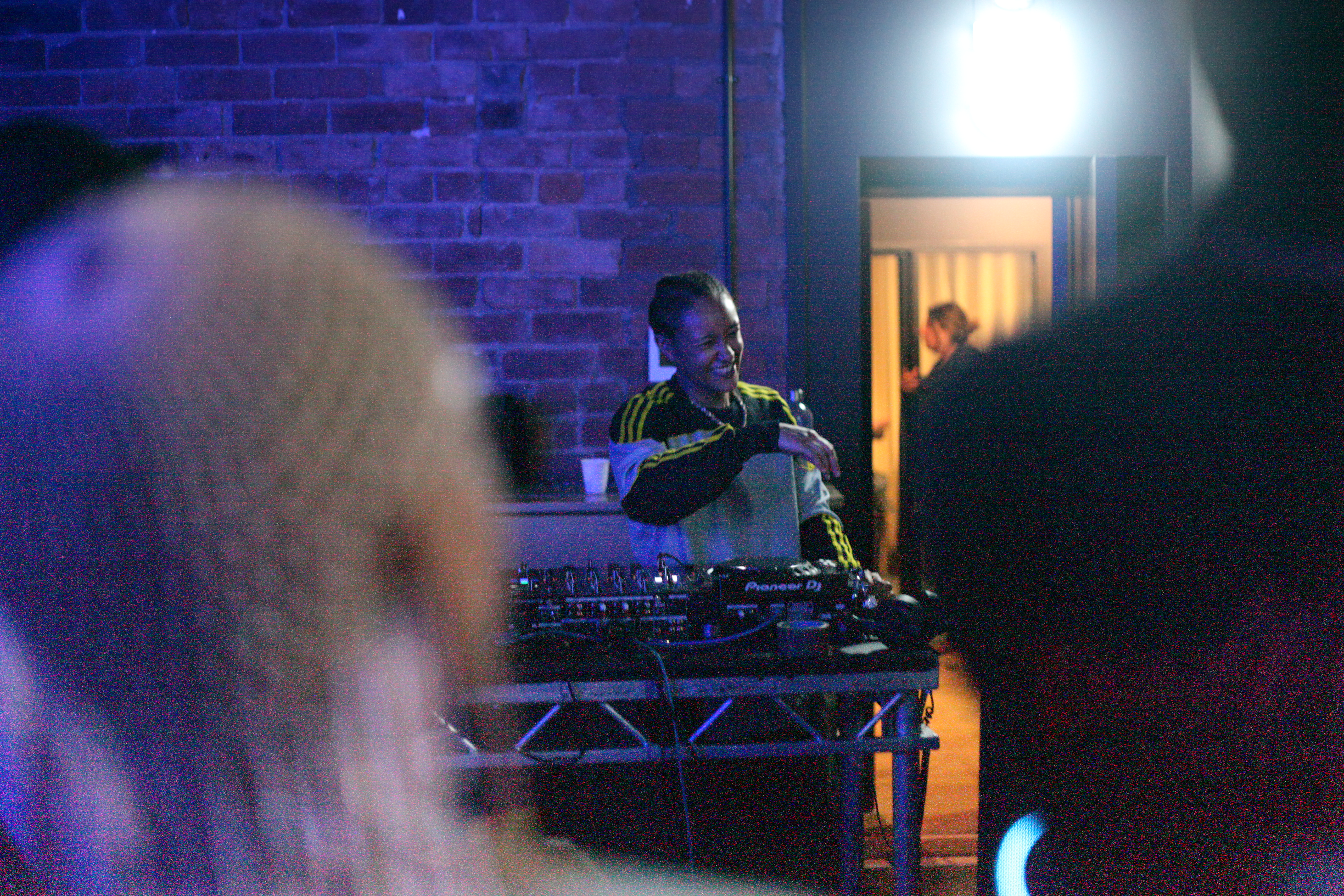 An Afro Energy participant on the decks with audience members in the corners.
