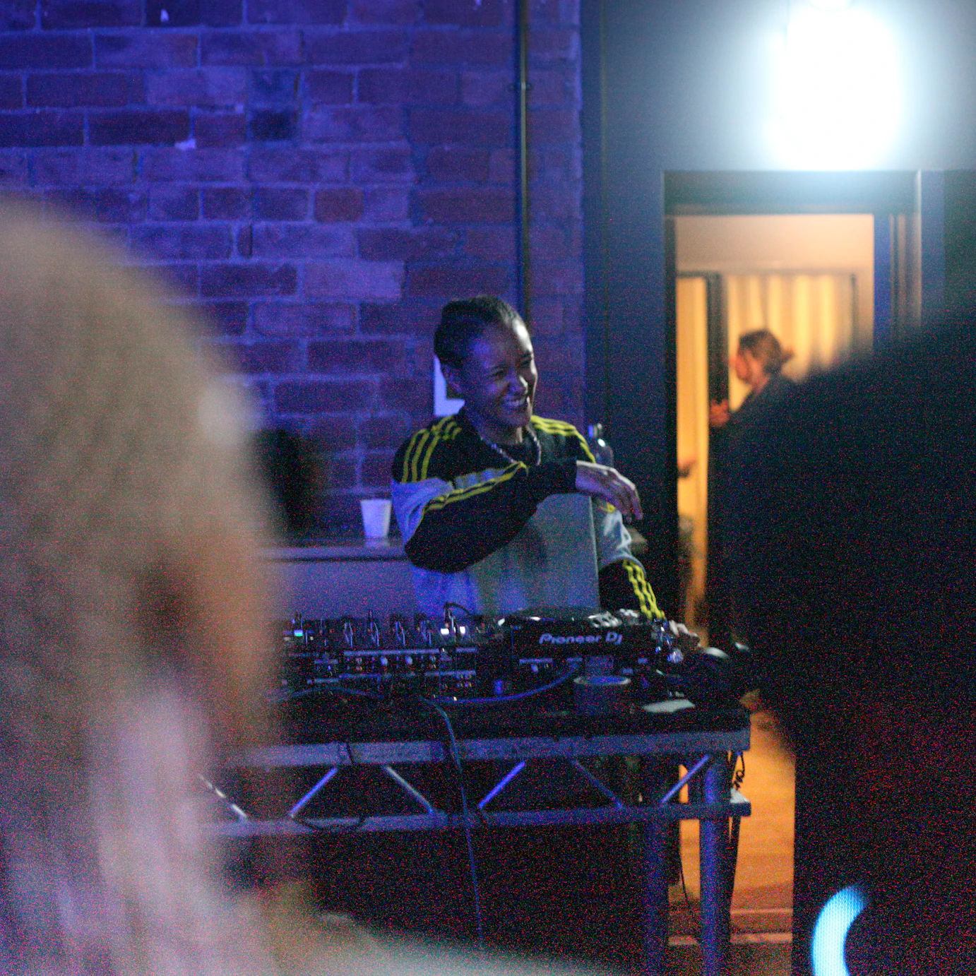 An Afro Energy participant on the decks with audience members in the corners.