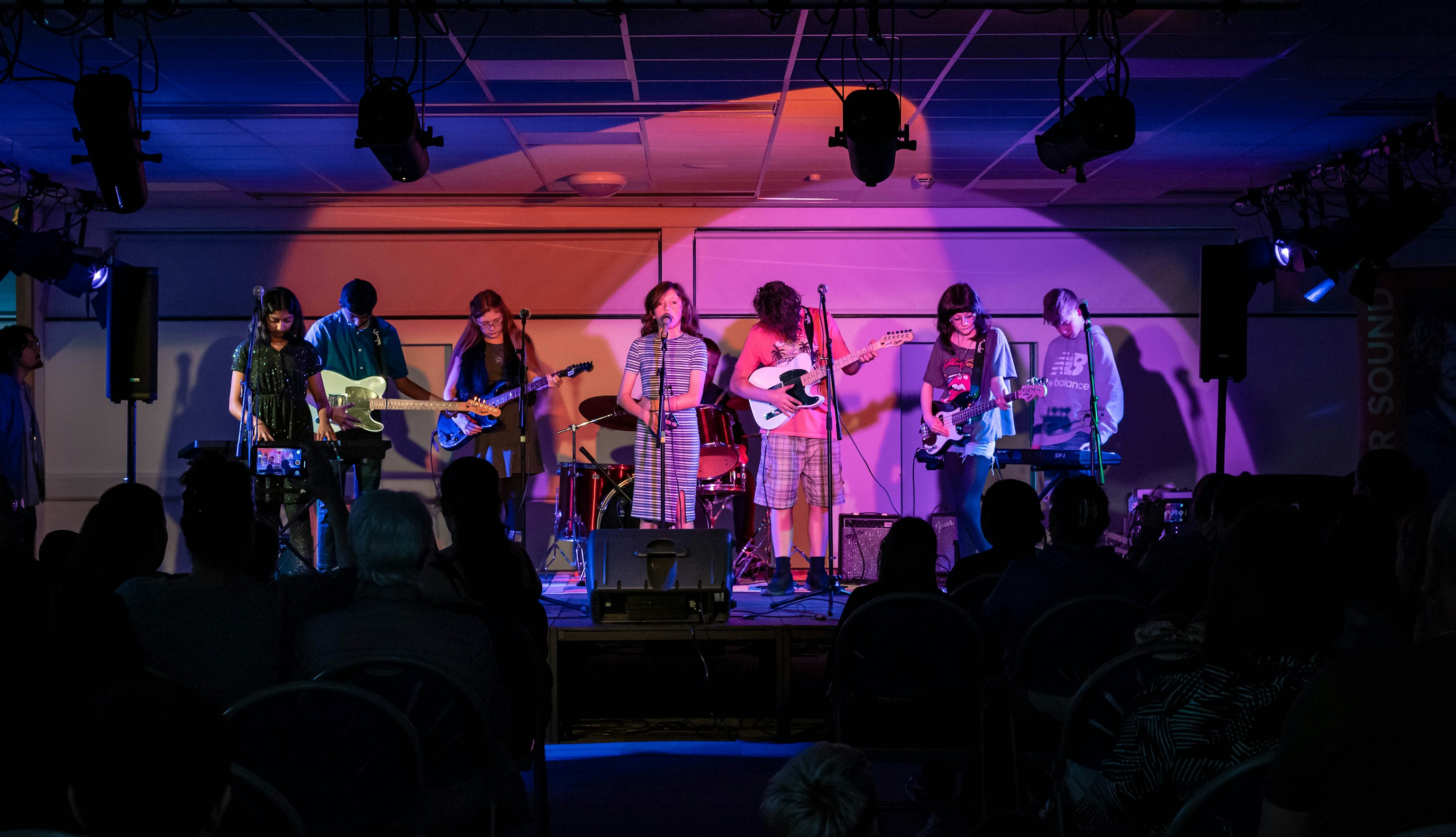 A wide shot of young people performing on stage at Wythenshawe Live Night.