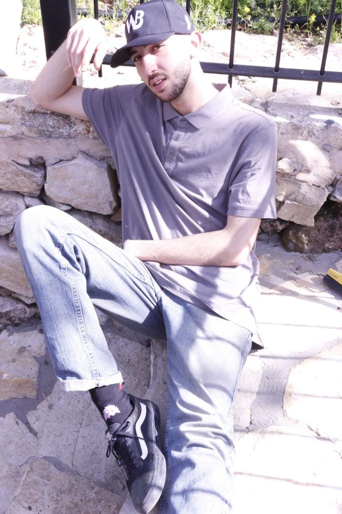 RUUQ sat and leaning against a stone wall.