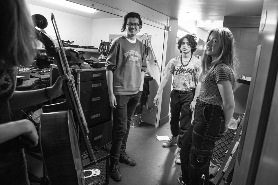 Tom and three other musicians backstage during a live event.