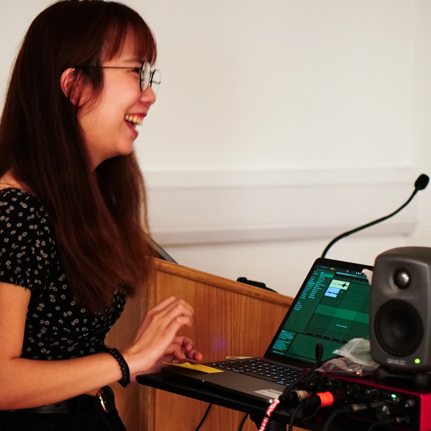 Katherine smiling in front of a laptop in rehearsals.