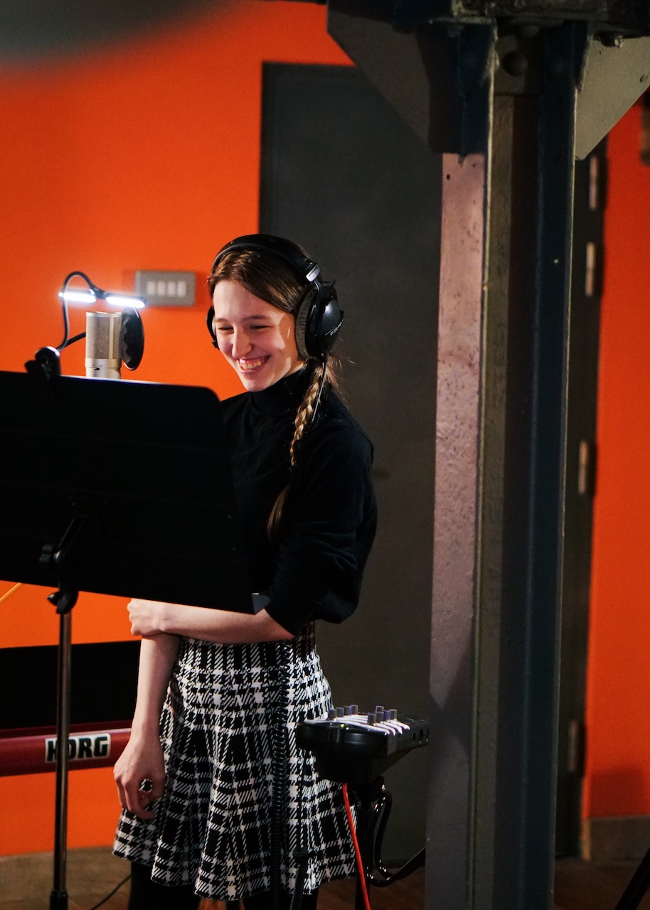 A young musician in VoltaLab with headphones on smiling.
