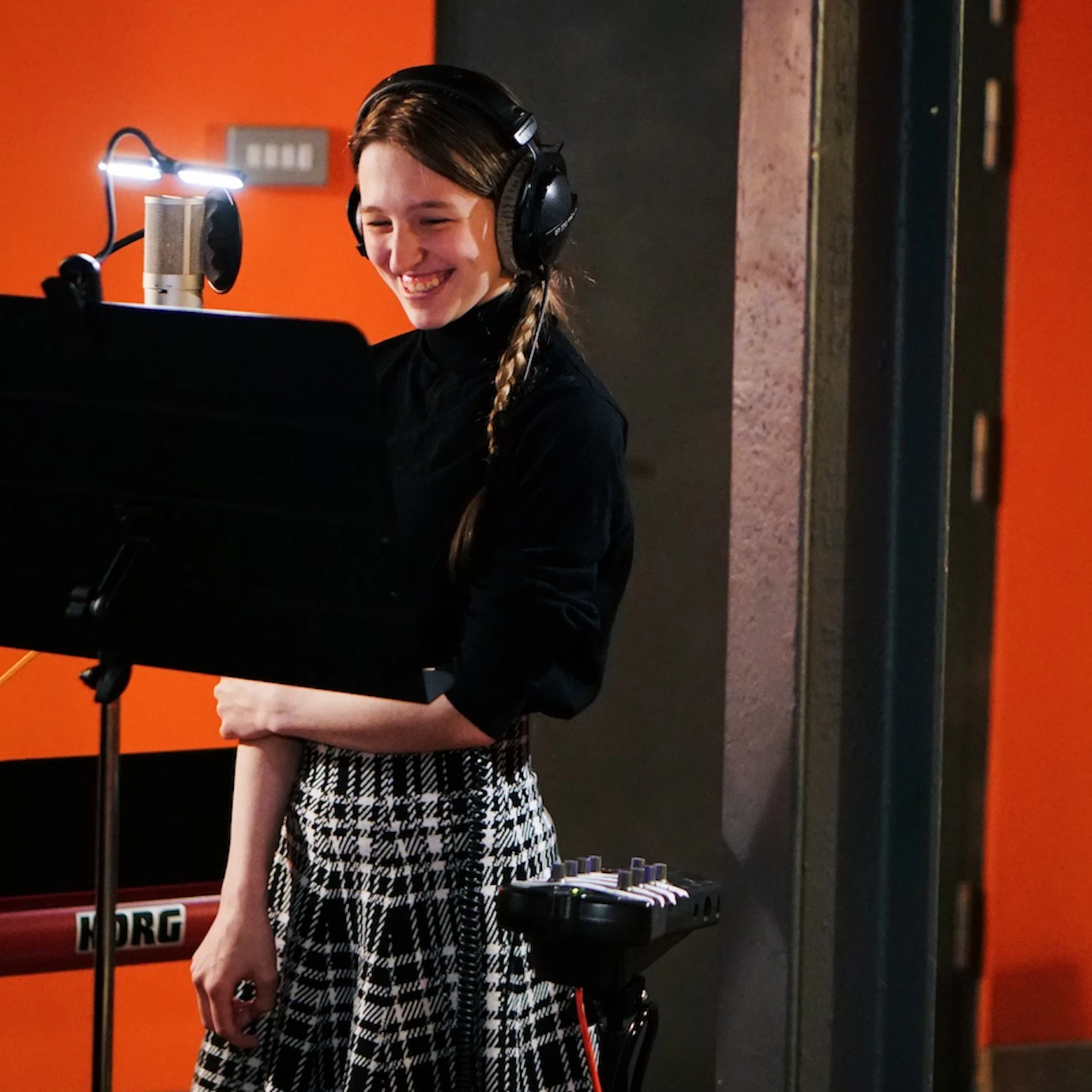 A young musician in VoltaLab with headphones on smiling.