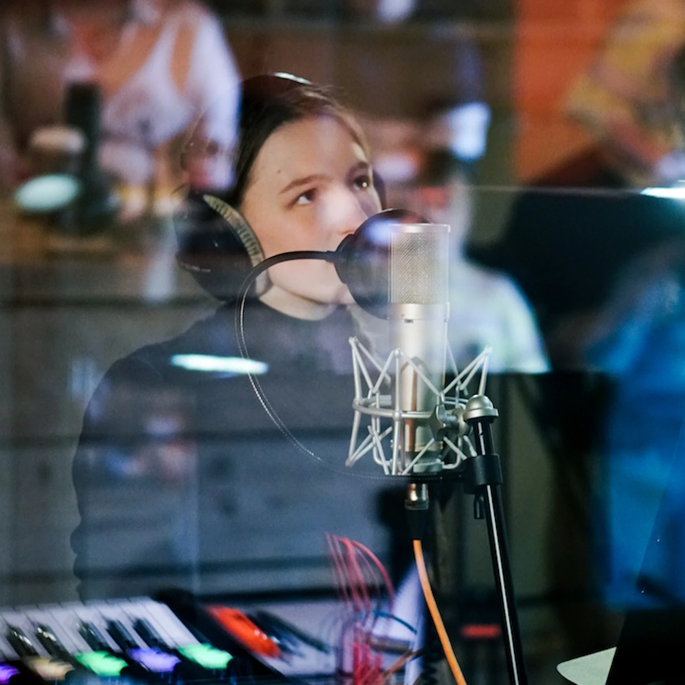 A young musician in VoltaLab with headphones on singing into a microphone.